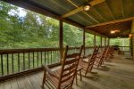 Main floor screen porch offers two picnic tables, rocking chairs, gas grill and hot tub